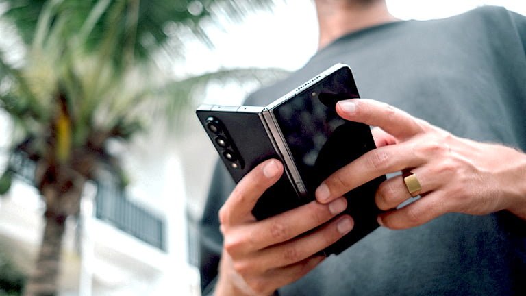 A man holding Samsung Galaxy Z Fold 4 that supports eSIM Samsung