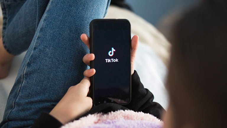 A child holding a smartphone and wondering how much data does TikTok use?