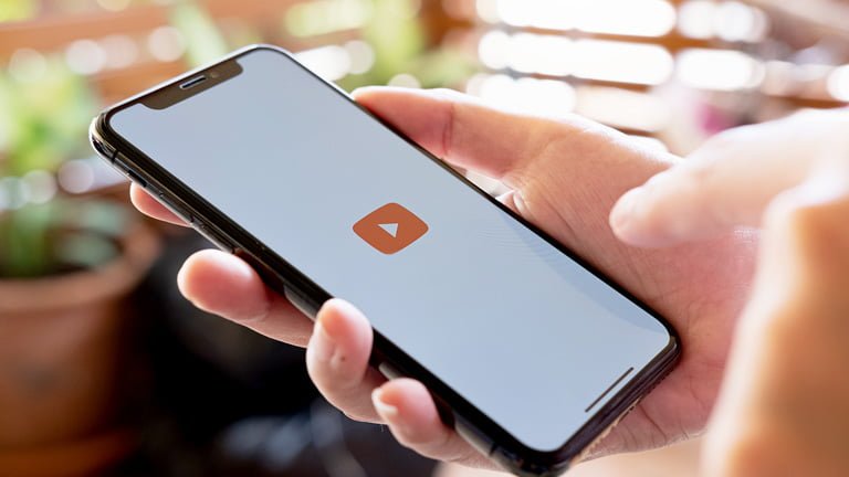 A hand with smartphone using YouTube wondering how much data does YouTube use