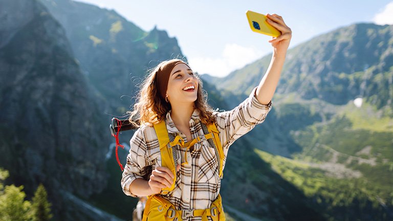 A-female-traveler-hiking-is-happy-about-data-connection-with-esim-usa-travel